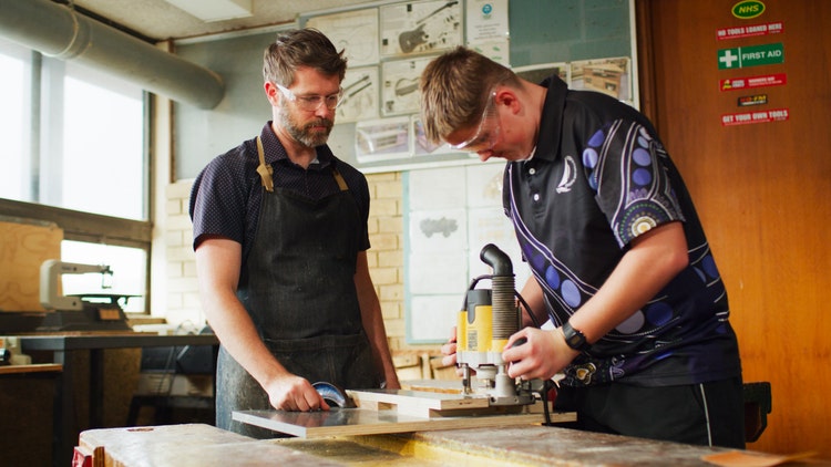 student and teacher in woodworking room
