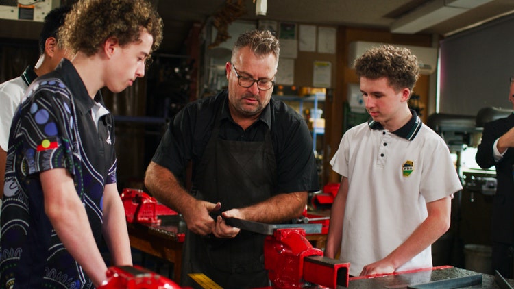 students and teacher in metalwork room