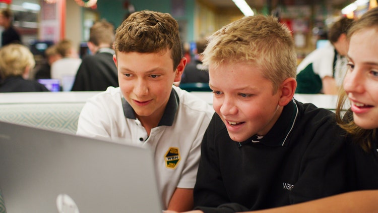 two boys looking at a computer